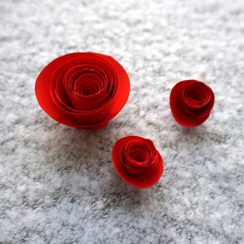 1 größere und 2 kleine fertige Rosen aus Papier.