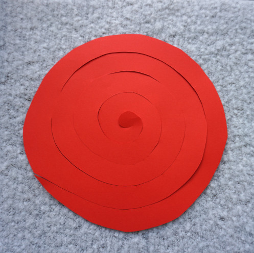 Kreis aus Papier ist zu einer Spirale geschnitten.